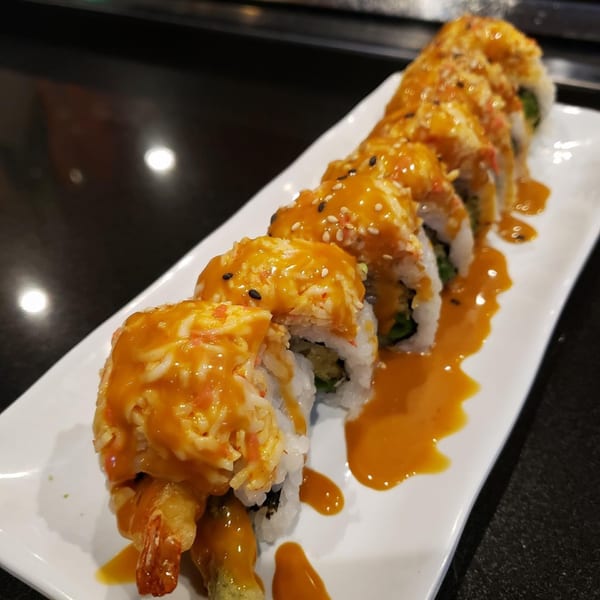 Awesome Sushi's tempura shrimp and crab sushi rolls, drizzled with orange sauce and sesame seeds.